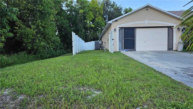 garage with a yard and central air condition unit