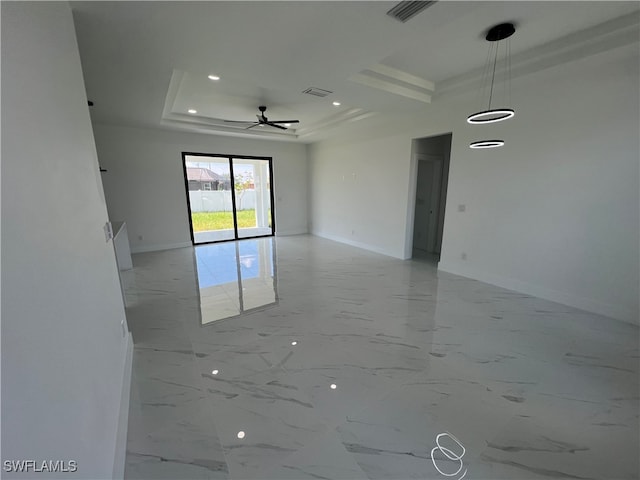 tiled spare room with ceiling fan and a raised ceiling