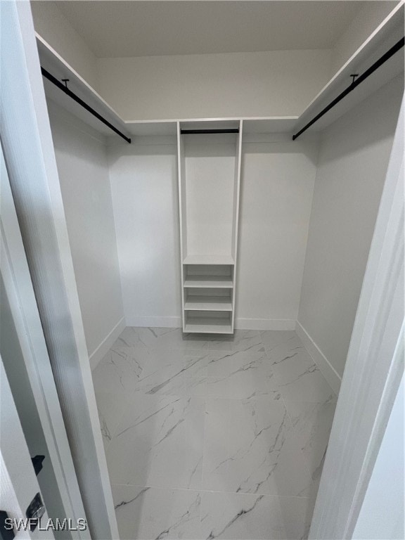 walk in closet with light tile patterned floors