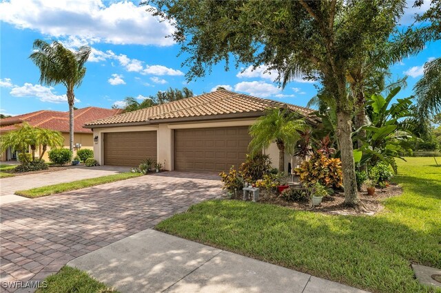 mediterranean / spanish house featuring a front lawn and a garage