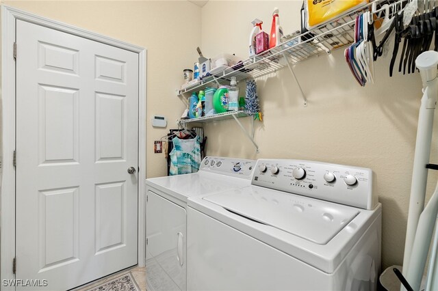 washroom featuring light tile patterned floors, laundry area, and washing machine and dryer