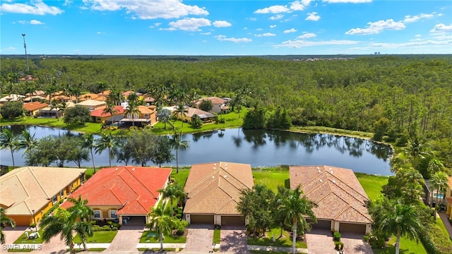 drone / aerial view with a residential view, a water view, and a forest view