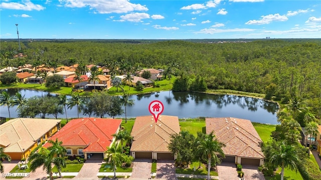 aerial view with a residential view, a water view, and a view of trees