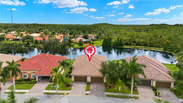 birds eye view of property with a water view and a view of trees