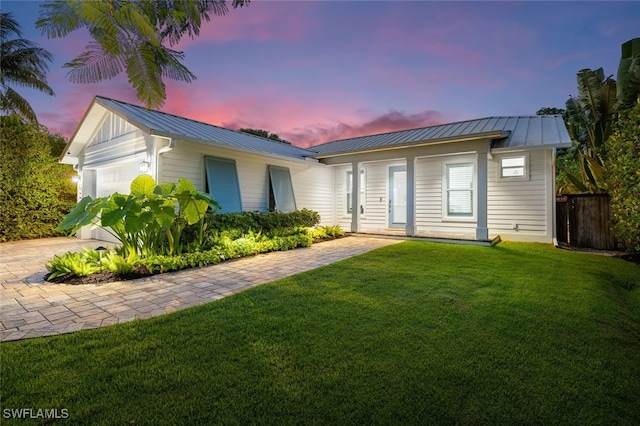 ranch-style house featuring a garage and a yard