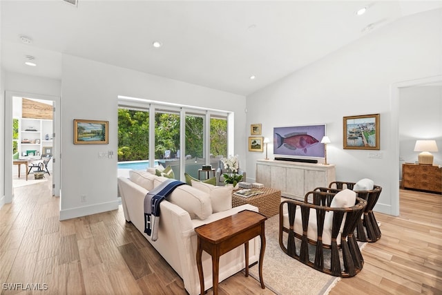 living room with vaulted ceiling and light wood-type flooring