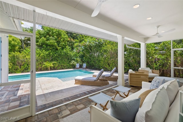 view of swimming pool with outdoor lounge area, ceiling fan, and a patio area