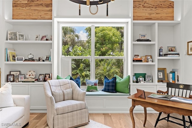 sitting room featuring built in shelves and light hardwood / wood-style floors