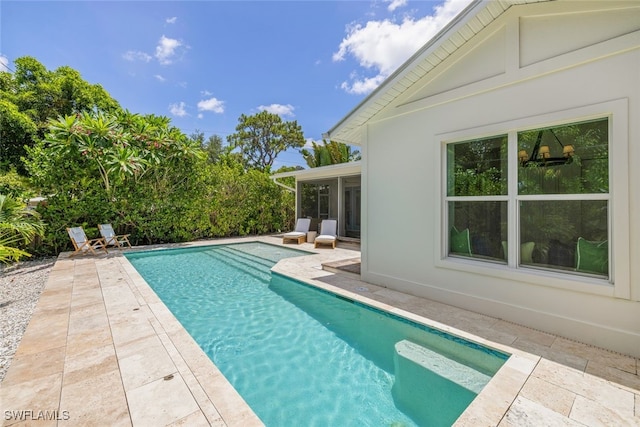 view of swimming pool with a sunroom and a patio