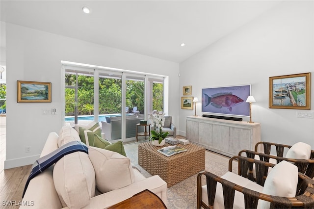 living room with light hardwood / wood-style floors and vaulted ceiling