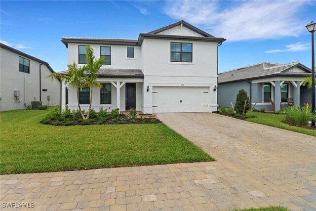 view of front of property with a garage, central AC, and a front lawn