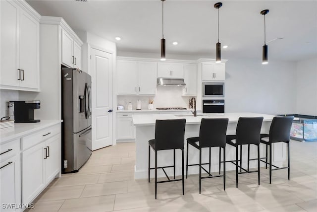 kitchen featuring stainless steel appliances, white cabinetry, sink, and pendant lighting