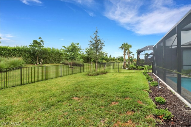 view of yard featuring a fenced in pool and glass enclosure