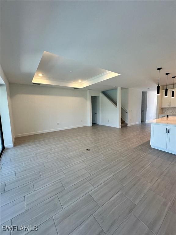 unfurnished living room with a tray ceiling