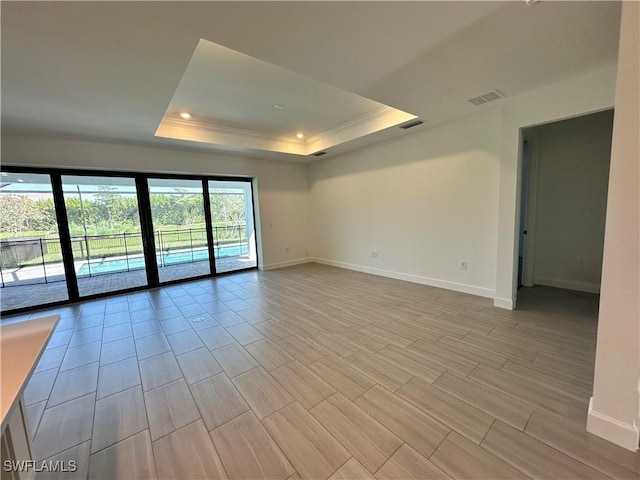 spare room with ornamental molding and a tray ceiling