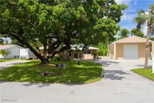 view of front of property featuring an outdoor structure, a garage, and a front lawn