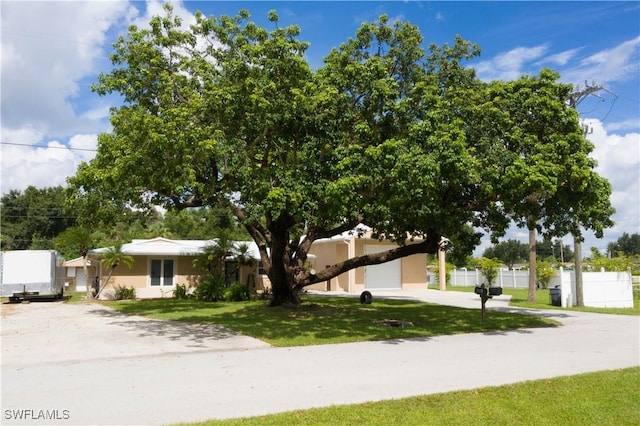 1418 Shirley Dr, North Fort Myers, FL 33917 - view of front facade featuring concrete driveway, a front lawn, and fence