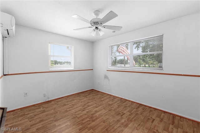 empty room with ceiling fan, wood-type flooring, and a wall mounted AC