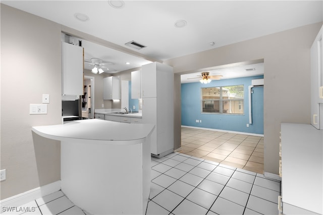 kitchen featuring light tile patterned floors, sink, ceiling fan, kitchen peninsula, and white cabinets