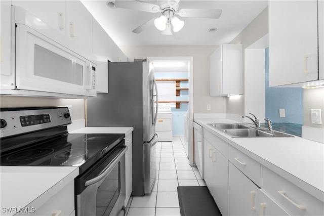 1418 Shirley Dr, North Fort Myers, FL 33917 - kitchen with light tile patterned floors, white microwave, washer / clothes dryer, stainless steel range with electric cooktop, and a sink
