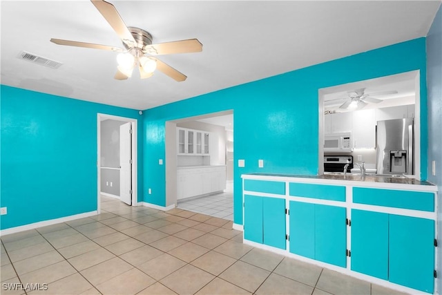 1418 Shirley Dr, North Fort Myers, FL 33917 - kitchen featuring white microwave, light tile patterned flooring, a sink, visible vents, and stainless steel fridge with ice dispenser