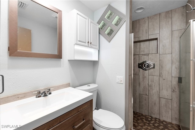 bathroom with toilet, vanity, and walk in shower