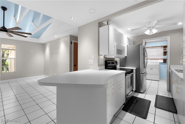 kitchen featuring light tile patterned floors, stainless steel electric range oven, washer / clothes dryer, and white cabinetry