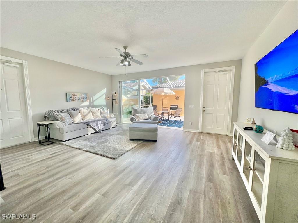 living room featuring light hardwood / wood-style flooring and ceiling fan