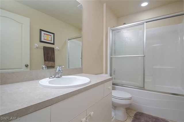 full bathroom featuring vanity, bath / shower combo with glass door, toilet, and tile patterned floors