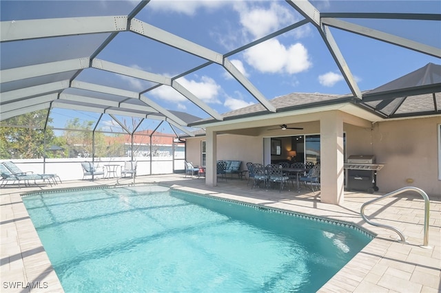 view of pool featuring a patio area, ceiling fan, grilling area, and glass enclosure