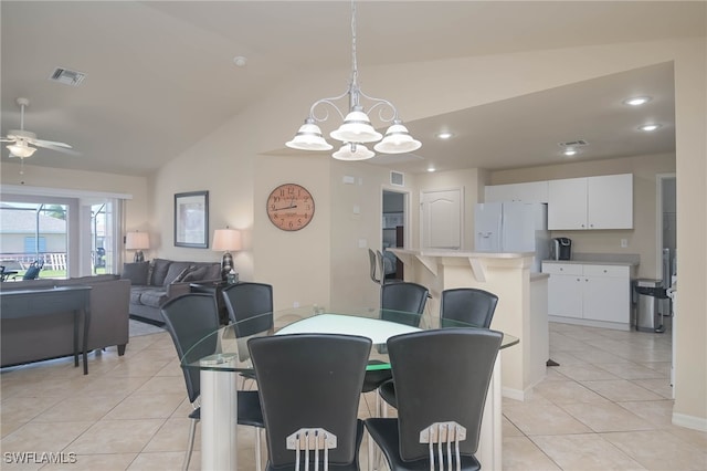 dining area featuring vaulted ceiling, ceiling fan with notable chandelier, and light tile patterned flooring