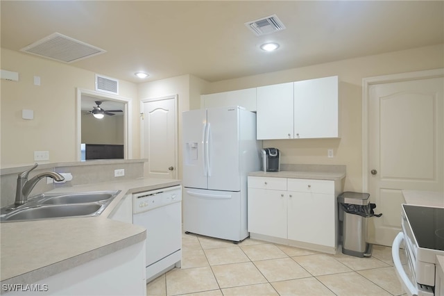 kitchen featuring white appliances, light tile patterned floors, sink, and white cabinets