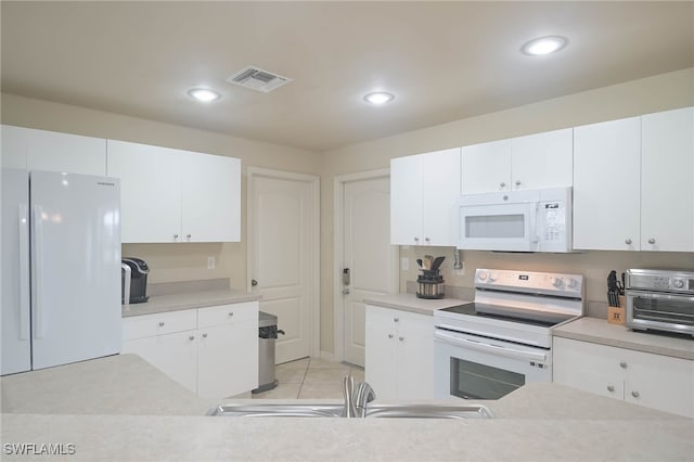 kitchen with sink, white cabinets, white appliances, and light tile patterned flooring