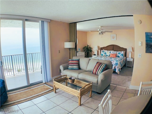 bedroom featuring access to exterior, a textured ceiling, ceiling fan, and light tile patterned flooring