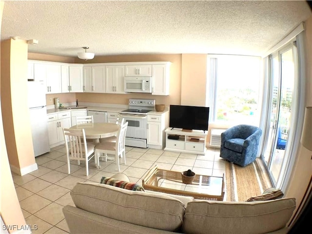 tiled living room featuring sink and a textured ceiling