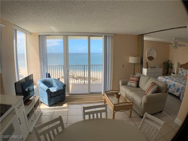 7330 Estero Blvd Unit 502, Fort Myers Beach, FL 33931 - living area with healthy amount of natural light, a textured ceiling, light tile patterned floors, and a ceiling fan