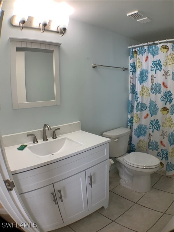 bathroom with toilet, vanity, tile patterned floors, and curtained shower