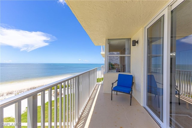 balcony with a water view and a beach view