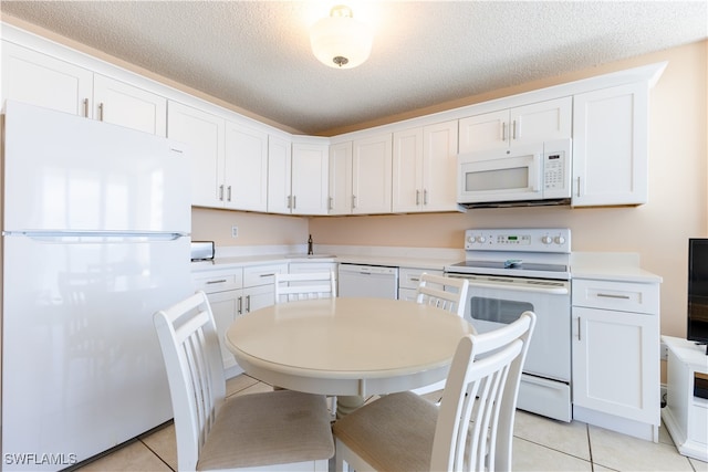 kitchen with white cabinets, white appliances, and a textured ceiling