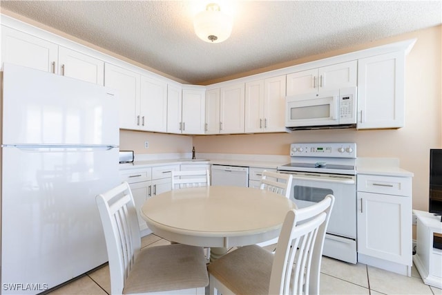 7330 Estero Blvd Unit 502, Fort Myers Beach, FL 33931 - kitchen featuring white appliances, a sink, light tile patterned floors, white cabinetry, and a textured ceiling