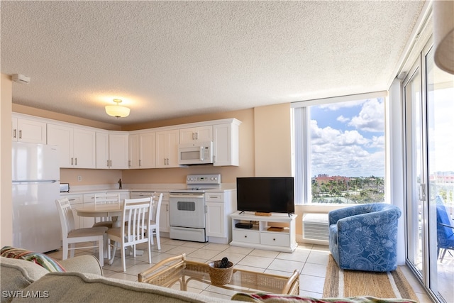 tiled living room with a wall mounted air conditioner, a textured ceiling, and a wealth of natural light