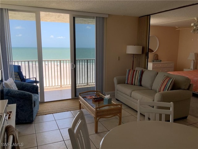 7330 Estero Blvd Unit 502, Fort Myers Beach, FL 33931 - living room featuring light tile patterned flooring, view of water and beach, a ceiling fan, and a textured ceiling
