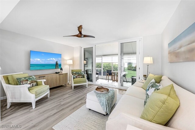 living room featuring light hardwood / wood-style flooring and ceiling fan