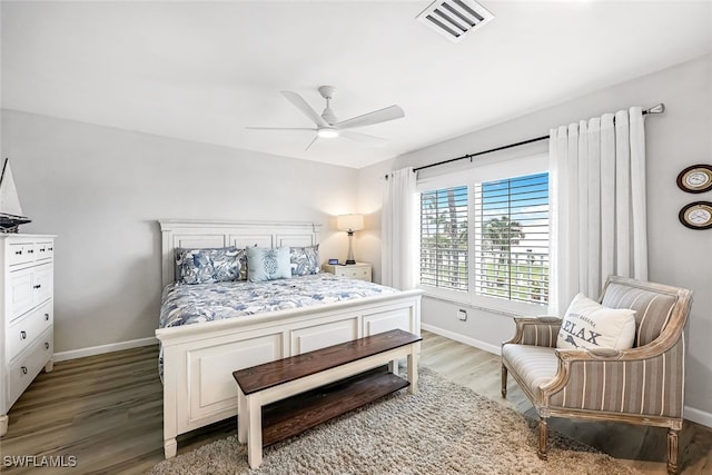 bedroom featuring ceiling fan, dark wood-style flooring, visible vents, and baseboards