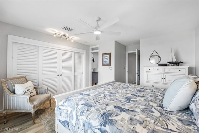 bedroom with light wood finished floors, ceiling fan, visible vents, and a closet