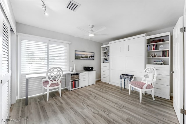 office space featuring light wood finished floors, visible vents, and a ceiling fan