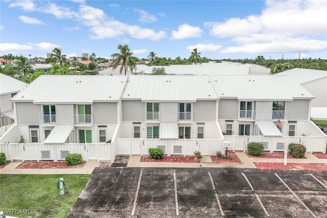 view of building exterior featuring fence private yard, uncovered parking, and a residential view