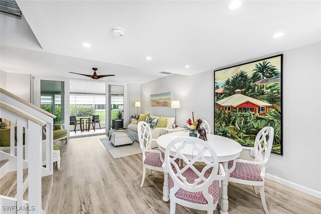 dining area featuring light wood-type flooring, a wall of windows, and ceiling fan