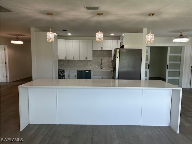 kitchen with dark hardwood / wood-style flooring, dishwashing machine, decorative backsplash, stainless steel refrigerator, and white cabinetry