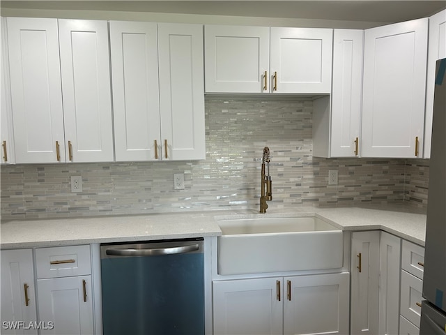 kitchen featuring white cabinets, decorative backsplash, stainless steel dishwasher, and sink